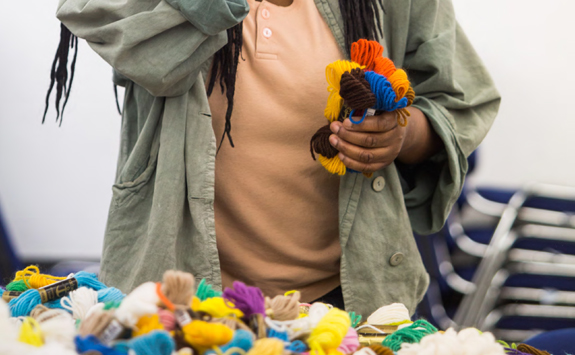 Woman holding bunchs colourful wool thread 